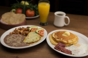 pancakes, eggs, bacon, coffee and orange juice